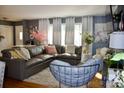 Inviting living room featuring a large sectional sofa, stylish curtains, and hardwood floors at 920 Squirrel Hill Rd, Charlotte, NC 28213