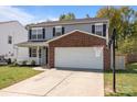 Charming two-story home with gray siding, brick accents, covered porch, two-car garage, and basketball hoop at 10937 Dry Stone Dr, Huntersville, NC 28078
