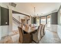 Elegant dining room featuring a wooden table, upholstered chairs, and a chandelier at 12525 Hashanli Pl, Matthews, NC 28105