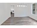 Bright dining room with wood floors and modern light fixture, next to the kitchen at 1409 Bloomsberry Ln, Waxhaw, NC 28173