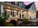 Inviting covered porch with rocking chairs and manicured landscaping gives this home great curb appeal at 1543 Ab Moore Jr Dr, Indian Trail, NC 28079
