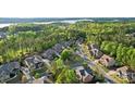 A picturesque view of a neighborhood surrounded by lush greenery and a serene lake in the distance at 16532 Flintrock Falls Ln, Charlotte, NC 28278