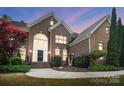 Brick home featuring an arched entryway, manicured landscaping and inviting front steps at 16532 Flintrock Falls Ln, Charlotte, NC 28278