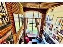 High-angle view of living room with exposed brick walls, large window, and decor at 201 S Hoskins Rd # 132, Charlotte, NC 28208