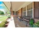 Inviting covered front porch featuring a cozy bench, decorative plants, and classic brick facade details at 2116 1St Avenue Nw Pl, Hickory, NC 28601