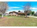 Traditional brick home featuring a well-manicured lawn and mature trees, enhancing its curb appeal at 2116 1St Avenue Nw Pl, Hickory, NC 28601