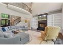 Spacious living room boasts a fireplace, built-in shelving, and an elegant staircase with a wrought-iron railing at 220 Palm Cove Way, York, SC 29745
