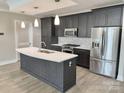 Modern kitchen featuring stainless steel appliances, island with white countertops and dark wood cabinets at 222 S Caldwell St # 1801, Charlotte, NC 28202