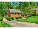 Lovely brick home with black shutters surrounded by lush greenery and a winding driveway at 2815 Burnt Mill Rd, Charlotte, NC 28210