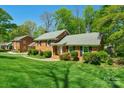 Charming brick home featuring a well-manicured lawn and lush landscaping, nestled on a beautiful lot at 2815 Burnt Mill Rd, Charlotte, NC 28210