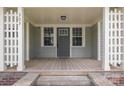 Inviting front porch with gray door and wood flooring, framed by white columns and number signage at 303 S Iredell Ave, Spencer, NC 28159