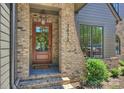 Inviting front entry with a wooden door, brick surround, house number, and decorative wreath at 3473 Willow Oak Rd, Charlotte, NC 28209