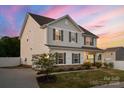 Side view of a two-story home featuring a driveway, a well-kept lawn, and white fencing at 3637 Allenby Pl, Monroe, NC 28110
