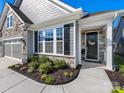 Inviting entrance with a stylish black front door, stone accents, and lush landscaping at 4012 Moxie Way, Charlotte, NC 28215