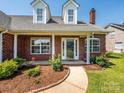 Inviting covered front porch with white pillars and well-kept landscaping, perfect for relaxing at 4203 Ethel Sustar Dr, Monroe, NC 28110