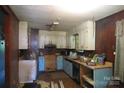 An outdated kitchen with mixed wood and white cabinets, needing renovation at 4814 Chapel Grove Rd, Gastonia, NC 28052