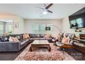 Bright living room features hardwood floors, large leather sectional, stylish furniture, and large windows at 5150 Mount Clare Ln, Charlotte, NC 28210