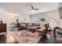 Spacious living room with hardwood floors, a large sectional couch, stylish furniture, and lots of natural light at 5150 Mount Clare Ln, Charlotte, NC 28210