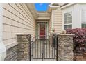 Inviting gated entrance with stone pillars leading to a charming red front door at 536 Wellbourne Nw Ct, Concord, NC 28027