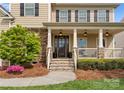 Inviting front porch with stone accents, pendant lighting, and a view of the landscaped front yard at 541 Nw Sutro Forest Dr, Concord, NC 28027