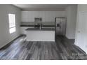 Modern kitchen featuring stainless steel appliances, a spacious island, and wood plank flooring at 574 30Th Avenue Ne Cir, Hickory, NC 28601