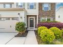 Inviting front entrance with stone detailing, colorful landscaping, and a two-car garage at 6702 Carradale Way, Charlotte, NC 28278