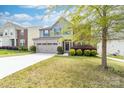 Charming two-story home featuring stone accents, a well-maintained lawn, and a two-car garage at 6702 Carradale Way, Charlotte, NC 28278