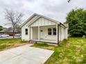 A cozy single-story home with a welcoming front porch and a concrete driveway on a cloudy day at 712 N Washington St, Shelby, NC 28150