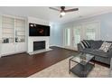 Cozy living room with a fireplace, built-in shelving, and French doors at 8251 Tradd Ct, Charlotte, NC 28210