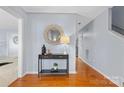 Inviting entryway featuring hardwood floors, neutral walls, stylish console table and decorative mirror at 9010 Davis Crossing Ct, Charlotte, NC 28269