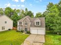 Charming two-story home featuring a stone facade, well-manicured lawn, and two-car garage at 9010 Davis Crossing Ct, Charlotte, NC 28269