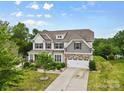 Two story home featuring a landscaped yard, large driveway, and neutral color palette at 9303 Raven Top Dr, Mint Hill, NC 28227