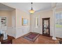 Inviting foyer with hardwood floors, wainscoting, and sophisticated decor creates a warm welcome at 9803 Tree Canopy Rd, Charlotte, NC 28277
