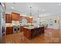 Spacious kitchen features a large island with seating, stainless steel appliances, and custom cabinetry at 9803 Tree Canopy Rd, Charlotte, NC 28277