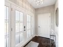 Bright foyer with elegant lighting, glass paneled front doors, and dark hardwood floors at 11228 Island View Ln, Lancaster, SC 29720