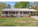 Attractive brick house with a metal roof, a front porch with white railings, and a well-manicured lawn at 1195 Ralph B Keener Rd, Lincolnton, NC 28092