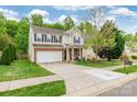 Beautiful two-story home with a spacious driveway, mature trees, and a well-manicured lawn at 13015 Rothe House Rd, Charlotte, NC 28273