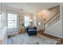 Inviting foyer with hardwood floors, staircase, and natural light streaming through the front door at 13015 Rothe House Rd, Charlotte, NC 28273