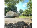 View of back of home and yard with a wooden deck and chain link fence surrounding the property at 1307 Washington Ln, Kannapolis, NC 28083