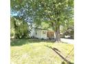 View of front exterior and front yard with covered porch and gravel driveway and mature tree at 1307 Washington Ln, Kannapolis, NC 28083
