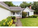 Inviting front entrance featuring a white door with a wreath, sidelights, and well-maintained landscaping at 13324 Kintyre Ct, Matthews, NC 28105