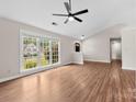 Bright living room showcasing vaulted ceilings, hardwood floors, and large windows with backyard views at 13324 Kintyre Ct, Matthews, NC 28105