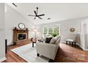Bright living room with a brick fireplace, hardwood floors, and large windows overlooking the yard at 13324 Kintyre Ct, Matthews, NC 28105