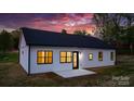 Rear exterior view highlighting the patio, black-framed windows, and modern design, perfect for outdoor living at 2045 Cordia Cir, Newton, NC 28658