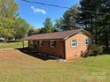 A single-story brick home showing side and back, has a well-maintained lawn and garden beds at 22 Heritage View Rd, Hickory, NC 28601