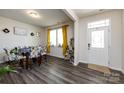 Bright dining room featuring stylish chairs, wood-look floors, modern decor, and natural light from the window at 3100 Cheyney Park Dr, Charlotte, NC 28269