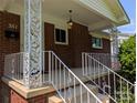 Close-up of a front porch with decorative columns, white railings, and a hanging porch light at 351 Glenwood Dr, Mooresville, NC 28115