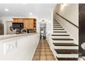 Bright hallway featuring tile flooring, staircase to the upper level, and access to other rooms at 4605 Hedgemore Dr # I, Charlotte, NC 28209