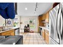 Bright kitchen featuring stainless steel appliances, wooden cabinetry, and tile floors at 4605 Hedgemore Dr # I, Charlotte, NC 28209