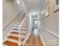 Bright hallway with hardwood floors, staircase and decorative wainscoting leading to a naturally lit area at 4607 Hedgemore Dr # H, Charlotte, NC 28209